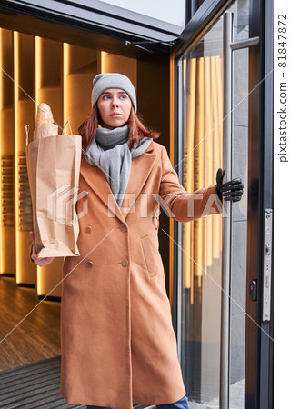 Woman with implant arm holding big paper bag with bread 81847872