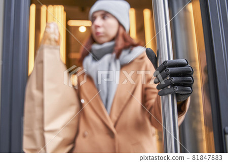 Woman with implant arm holding big paper bag with bread 81847883