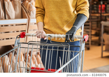 Woman with artificial limb doing grocery shopping at the supermarket 81848076