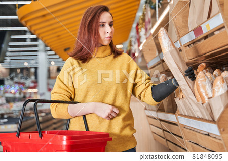 Woman with implant arm looking at the bread at grocery store 81848095