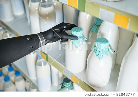 Woman implant hand taking bottle of milk from shelf 81848777