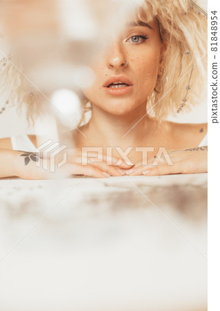 Woman looking from behind the glass while keeping her mouth open Woman looking from behind the glass while keeping her mouth open 81848954