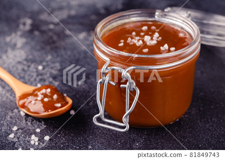 Glass jar with tasty delicious salted caramel 81849743