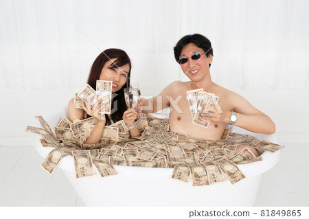 Bubbly men and women taking a wad of bills bath 81849865