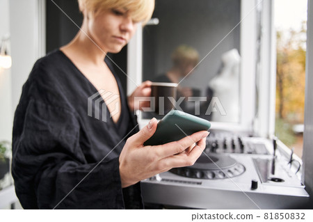 Dj woman looking at her smartphone 81850832