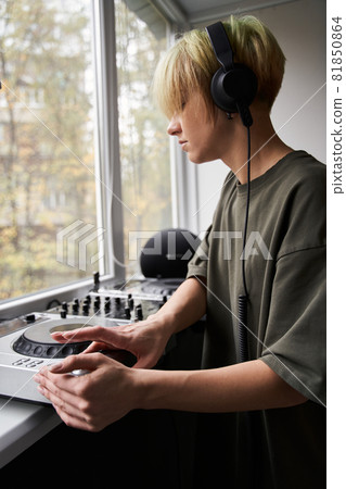 Music editor hand tweaking volume knob on audio interface 81850864