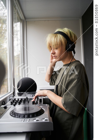 Woman sound engineer adjusting her headphone Woman sound engineer adjusting her headphone 81850869
