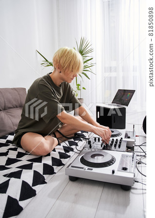 Girl using professional DJ midi controller and audio mixer Girl using professional DJ midi controller and audio mixer 81850898