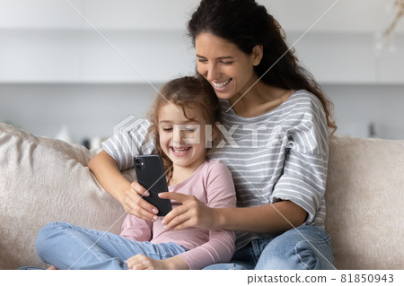 Happy mother and small daughter using cellphone apps. 81850943