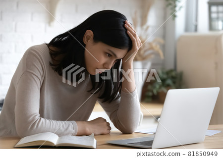 Confused unhappy young korean asian woman looking at laptop screen. Confused unhappy young korean asian woman looking at laptop screen. 81850949