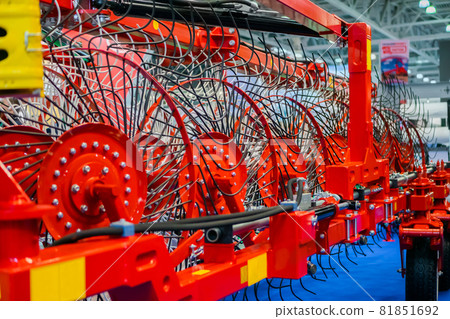 Red tractor rotary wheel hay and tedding rakes at farming exhibition Red tractor rotary wheel hay and tedding rakes at farming exhibition 81851692