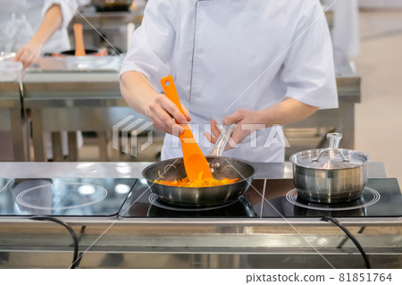 Chef hands cooking vegetables - sliced bell pepper, onion in frying pan 81851764