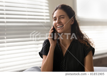 Happy excited Latin woman talking on mobile phone 81851905