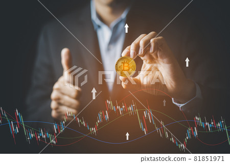 Businessman Hand holding Bitcoin New virtual money coin over us dollars close up, Digital Money and Bitcoin Concept. Cryptocurrency golden coin, stock exchange graph background. Digital money concept. 81851971