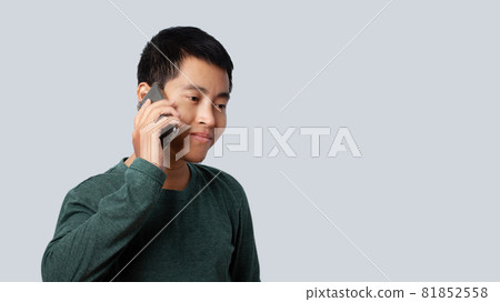 Portrait of Asia man talking smartphone isolated on gray background. Portrait of Asia man talking smartphone isolated on gray background. 81852558
