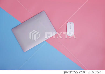 Laptop and wireless mouse on pink and blue background. copy space. top view. Laptop and wireless mouse on pink and blue background. copy space. top view. 81852573