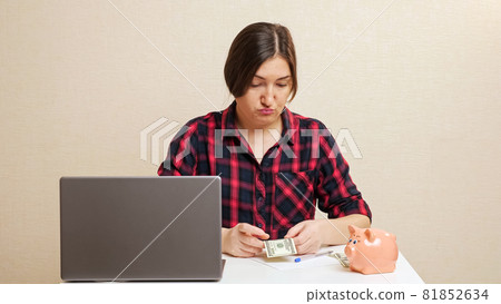 Lady plans budget inserting dollar bill into piggy bank Lady plans budget inserting dollar bill into piggy bank 81852634