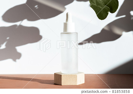 Cosmetic mock up background. Serum with peptides in glass bottle on wooden geometric podium, scene natural plant shadows. Cosmetics product mockup. Skin care concept. Beauty blogging Cosmetic mock up background. Serum with peptides in glass bottle on wooden geometric podium, scene natural plant shadows. Cosmetics product mockup. Skin care concept. Beauty blogging 81853858