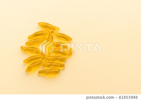 Fish oil supplement capsules omega-3 isolated on yellow surface. Health care concept 81853998