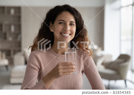 Portrait of happy millennial woman holding glass of water. Portrait of happy millennial woman holding glass of water. 81854385