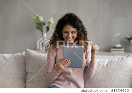 Overjoyed emotional young latina woman celebrating internet success. Overjoyed emotional young latina woman celebrating internet success. 81854450