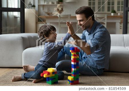 Happy millennial dad giving praise and high five to son 81854509