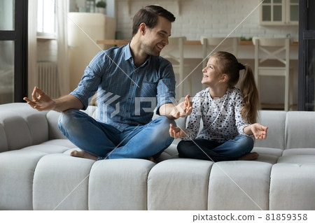 Happy millennial dad teaching cute 7s daughter to meditate 81859358
