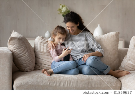 Happy two female generations family using telephone gadget. Happy two female generations family using telephone gadget. 81859657