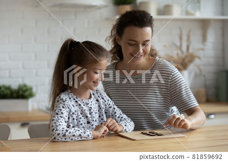 Happy engaged mom and daughter kid enjoying in board game 81859692