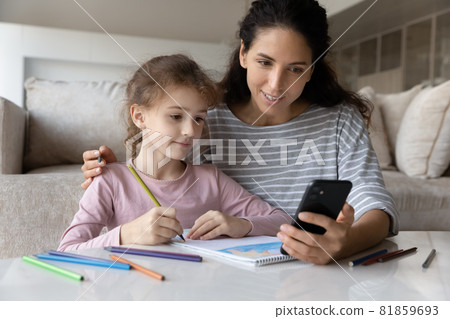Smiling young mother drawing with small daughter. Smiling young mother drawing with small daughter. 81859693