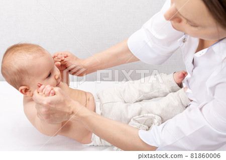 Physiotherapist performing sit-up exercise with little baby building core strength Physiotherapist performing sit-up exercise with little baby building core strength 81860006