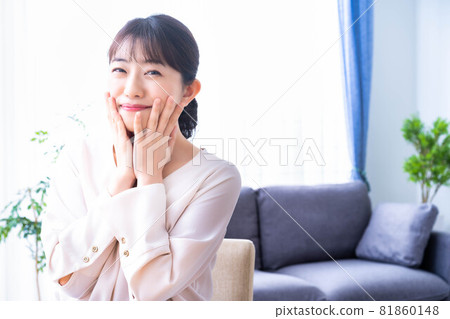 A woman who feels the moisture of her skin with face care A woman who feels the moisture of her skin with face care 81860148