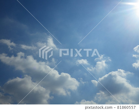 Blue sky with white clouds slightly off the sun 81860557