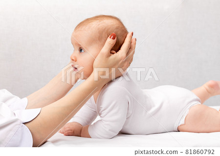 Little baby receiving osteopathic treatment of head and neck 81860792