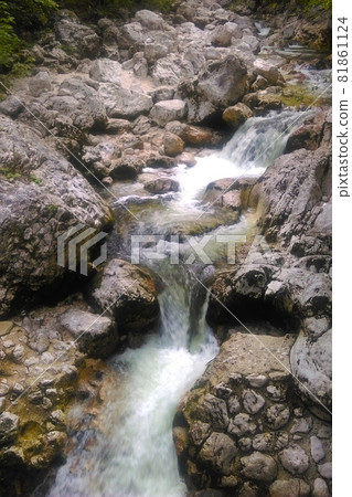 Cold clean water flows over the rocks in the mountains. Cold clean water flows over the rocks in the mountains. 81861124