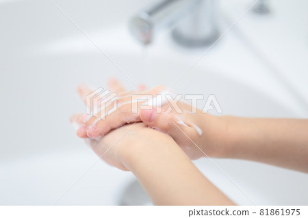Girl washing hands with hand soap on the wash basin Girl washing hands with hand soap on the wash basin 81861975