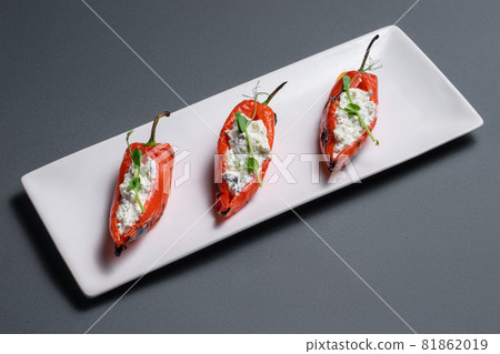 closeup of bulgarian peppers stuffed with cottage cheese on black background closeup of bulgarian peppers stuffed with cottage cheese on black background 81862019