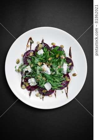 top view of healthy salad with beet, arugula and feta cheese on black background 81862021
