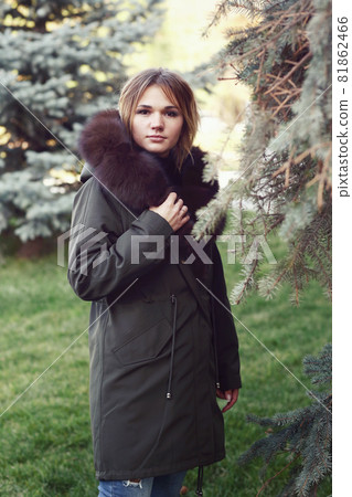 blond business woman in fox fur down jacket with hood closeup photo on city park background blond business woman in fox fur down jacket with hood closeup photo on city park background 81862466