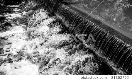Small waterfall on the forest stream. Gaden stone sluice in tranquil forest mood. Black and white image. Small waterfall on the forest stream. Gaden stone sluice in tranquil forest mood. Black and white image. 81862763