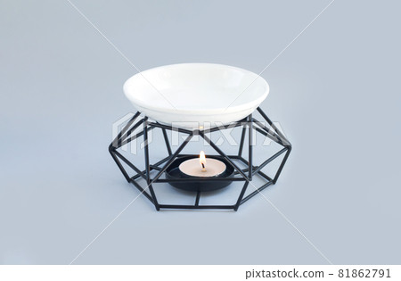 Aroma lamp or oil burner with burning candle and essential oils 81862791