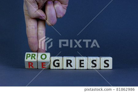 Regress or progress symbol. Businessman turns wooden cubes and changes the word 'regress' to 'progress'. Beautiful grey table, grey background, copy space. Business, regress or progress concept. 81862986