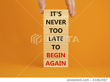 Begin again symbol. Wooden blocks with words 'It is never too late to begin again'. Businessman hand. Beautiful orange background, copy space. Business and It is never too late to begin again concept. Begin again symbol. Wooden blocks with words 'It is never too late to begin again'. Businessman hand. Beautiful orange background, copy space. Business and It is never too late to begin again concept. 81862987