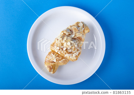 Croissant with almonds on a white plate. 81863135