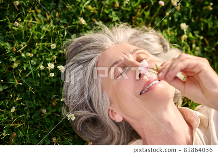 Close-up face of woman lying on grass Close-up face of woman lying on grass 81864036