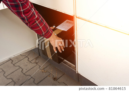 Pickup parcel. Courier box in woman hands at post delivery automat terminal. Self service post terminal and parcel delivery concept. 81864615