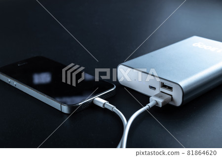 Power bank charger. Portable powerbank with white usb cable for charger mobile phone or smartphone battery. External battery for mobile devices. Power bank charger. Portable powerbank with white usb cable for charger mobile phone or smartphone battery. External battery for mobile devices. 81864620