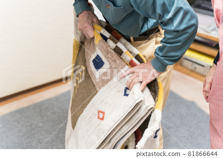 Senior man laying rugs for the hot carpet 81866644