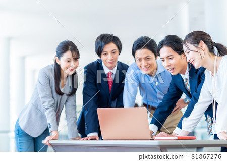 Young businessman looking at a computer Young businessman looking at a computer 81867276