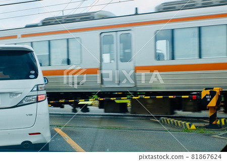 Car waiting for a passing train at a railroad crossing Car waiting for a passing train at a railroad crossing 81867624